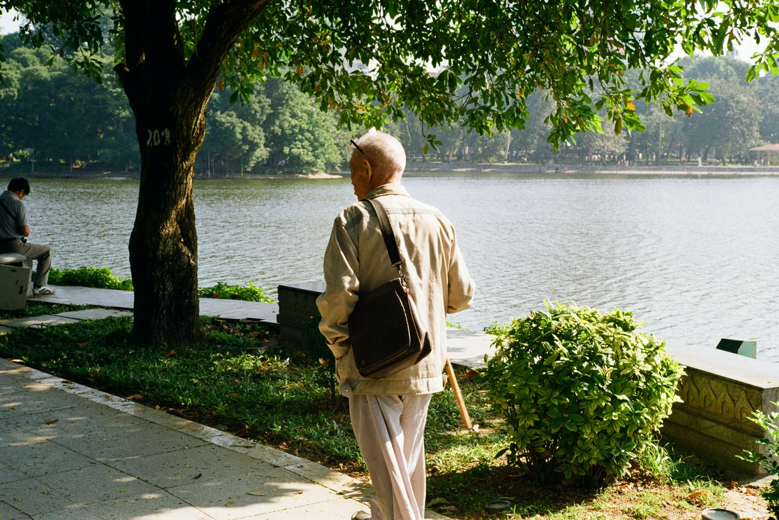 Older man walking beside a lake